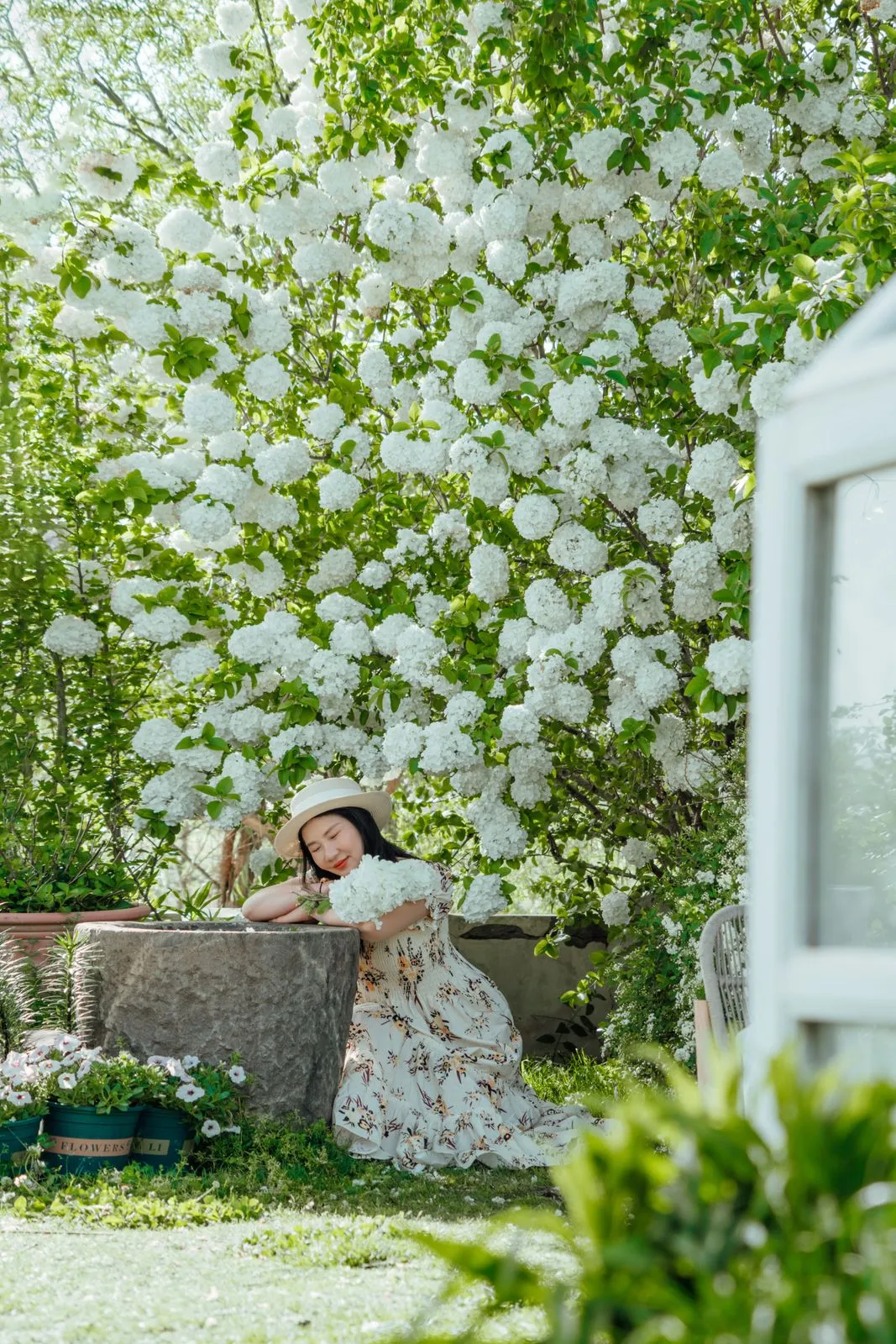 Mujer descansando en un jardín de flores blancas