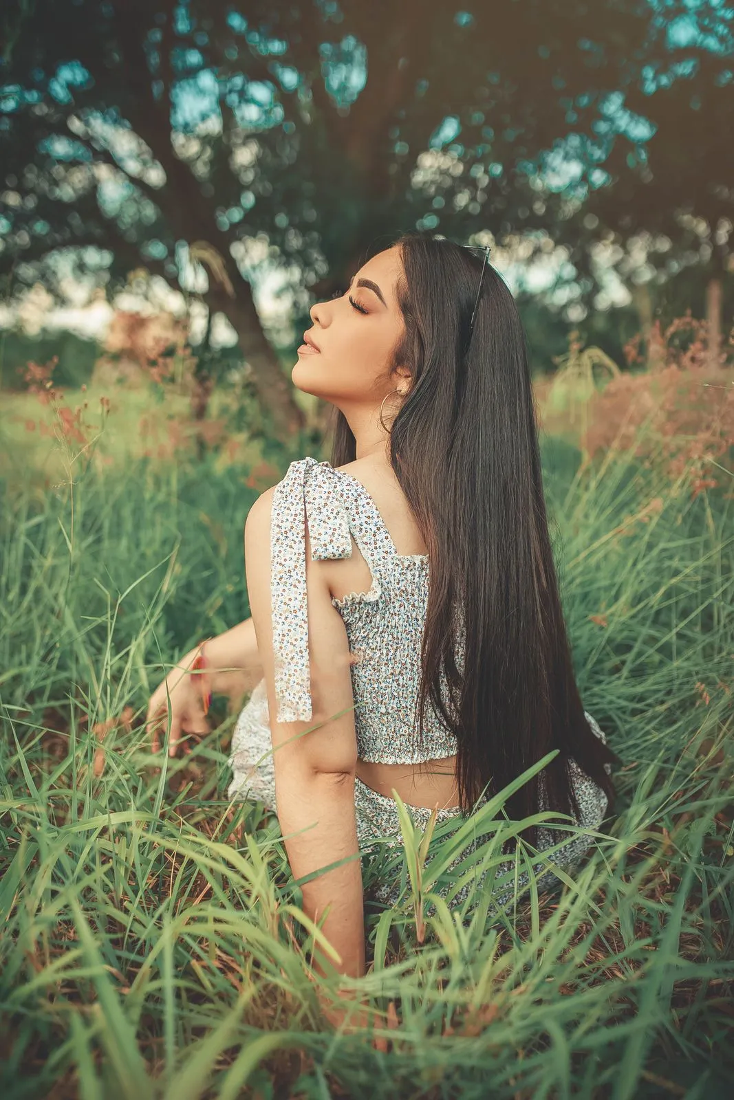 Mujer descansando entre hierba y árboles