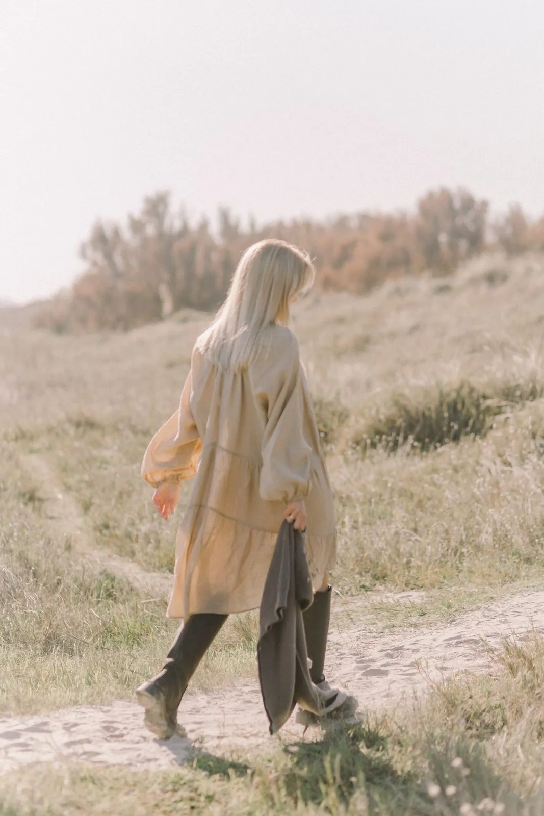 Mujer caminando por un sendero entre vegetación